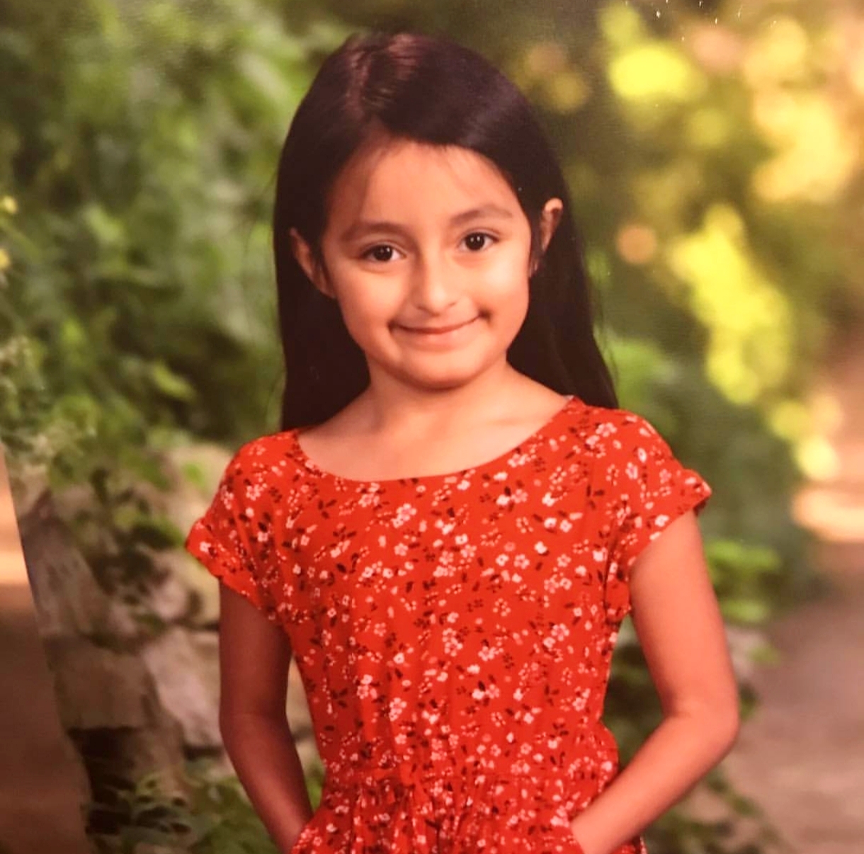 Childhood portrait of Miah in a red dress