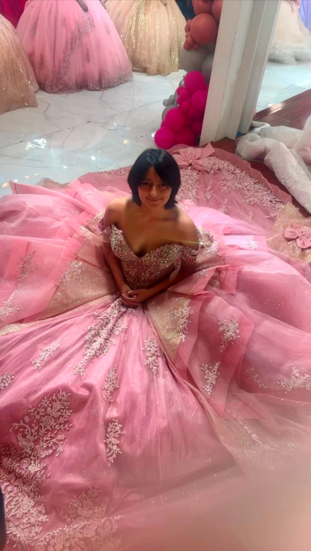Miah seated in a pink ballgown
